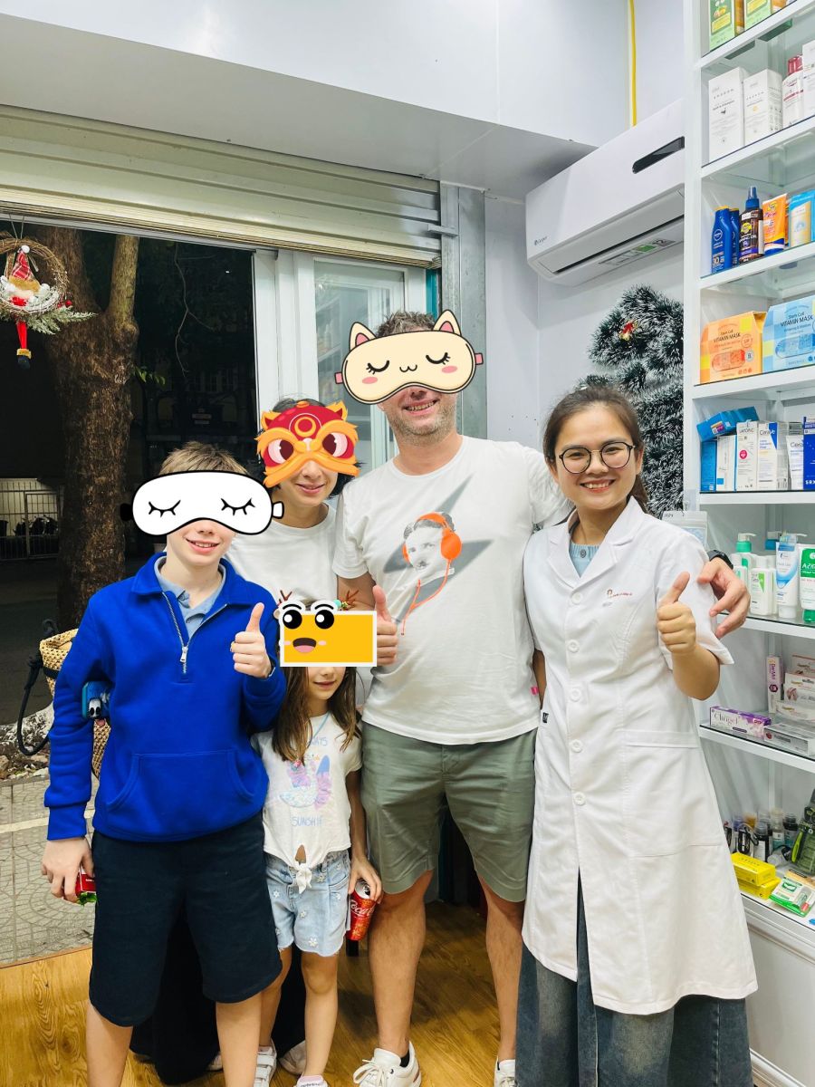 Happy traveler taking a photo with a pharmacist at ABC Pharmacy in Hue after receiving helpful support